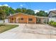 Well-maintained single-story home with a spacious driveway and mature trees at 713 715 W Fribley St, Tampa, FL 33603
