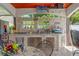 Covered outdoor kitchen offers granite counters, stainless appliances, and comfortable seating for entertaining at 713 715 W Fribley St, Tampa, FL 33603