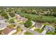 Community aerial view featuring manicured lawns, lush trees, and a nearby golf course at 7499 Blue Skies Dr, Spring Hill, FL 34606