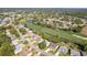 Aerial view showcases the community's golf course, green spaces, pond and well-maintained homes at 7499 Blue Skies Dr, Spring Hill, FL 34606