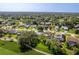 Aerial view of a residential neighborhood with manicured lawns and mature trees at 7499 Blue Skies Dr, Spring Hill, FL 34606