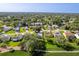 An aerial view showcasing the community with lush green landscaping, mature trees, and well-maintained homes at 7499 Blue Skies Dr, Spring Hill, FL 34606