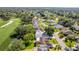 Aerial view showcasing homes near a golf course and lush greenery at 7499 Blue Skies Dr, Spring Hill, FL 34606