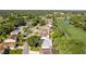 Property aerial showcases lush greenery, golf course, nearby lake, and well-maintained neighborhood at 7499 Blue Skies Dr, Spring Hill, FL 34606