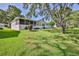 Lush backyard featuring an enclosed patio and beautiful landscaping in a desirable community with mature trees at 7499 Blue Skies Dr, Spring Hill, FL 34606