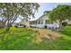 Spacious backyard with an enclosed patio, mature trees, meticulous landscaping, and well-maintained lawn at 7499 Blue Skies Dr, Spring Hill, FL 34606