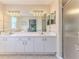 Bathroom with a double sink vanity, large mirror, and shower with glass doors at 7499 Blue Skies Dr, Spring Hill, FL 34606