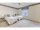 A cozy bedroom with twin beds, a window, and soft carpet presents a restful and inviting space at 7499 Blue Skies Dr, Spring Hill, FL 34606