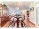 Dining room features wood table, chairs, chandelier, and hardwood floors that lead to living area at 7499 Blue Skies Dr, Spring Hill, FL 34606