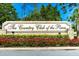 The Country Club of the Pines entrance sign surrounded by lush landscaping and beautiful flowers at 7499 Blue Skies Dr, Spring Hill, FL 34606