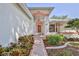 Inviting front entrance with colorful landscaping and a covered walkway leading to the front door at 7499 Blue Skies Dr, Spring Hill, FL 34606