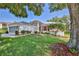 Well maintained home with a manicured lawn and mature trees at 7499 Blue Skies Dr, Spring Hill, FL 34606