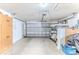Spacious garage with ample storage cabinets, room for a golf cart and a door that leads to the outside at 7499 Blue Skies Dr, Spring Hill, FL 34606