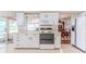 Bright kitchen featuring white cabinetry, countertops and appliances; open to dining area at 7499 Blue Skies Dr, Spring Hill, FL 34606