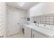 Well-lit laundry room featuring tile floor, washer, dryer, sink, and upper cabinets for optimal home convenience at 7499 Blue Skies Dr, Spring Hill, FL 34606