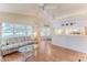 The living room boasts natural light, wood-look flooring, and views of the golf course at 7499 Blue Skies Dr, Spring Hill, FL 34606
