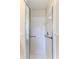 Bathroom shower with white tiles, glass doors, and a chrome showerhead and grab bar at 7499 Blue Skies Dr, Spring Hill, FL 34606
