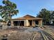 New construction with walls up and some lumber strewn around the sandy lot and surrounding trees at 7583 St Andrews Blvd, Weeki Wachee, FL 34613