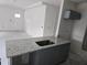 This kitchen island has grey cabinets and granite countertops, creating an attractive workspace for cooking at 7583 St Andrews Blvd, Weeki Wachee, FL 34613