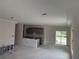 Spacious, unfinished living room area with gray kitchen cabinets and sliding doors, showing the open concept design at 7583 St Andrews Blvd, Weeki Wachee, FL 34613