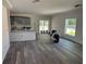 Spacious living room featuring gray vinyl plank flooring, abundant natural light, and an open concept layout at 7583 St Andrews Blvd, Weeki Wachee, FL 34613