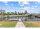 Tranquil backyard view featuring a walkway to the private dock and canal access at 7626 Hatteras Dr, Hudson, FL 34667