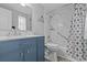 Bathroom featuring blue vanity, and shower with marble-style walls at 7626 Hatteras Dr, Hudson, FL 34667
