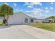 Single-story home with a white exterior, attached garage, and well-maintained lawn under a bright sky with puffy clouds at 7626 Hatteras Dr, Hudson, FL 34667