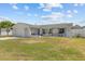 Attractive single-story house with a white exterior, attached garage, and a neatly manicured lawn under a blue sky at 7626 Hatteras Dr, Hudson, FL 34667