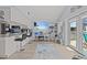 Open kitchen with white cabinets, a breakfast bar, stainless appliances, and a view of the living area and outdoors at 7626 Hatteras Dr, Hudson, FL 34667