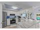 Modern kitchen with stainless steel appliances, granite countertops, blue backsplash, and a cozy eat-in dining area at 7626 Hatteras Dr, Hudson, FL 34667