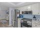 Kitchen featuring stainless steel appliances, blue backsplash, and light wood flooring at 7626 Hatteras Dr, Hudson, FL 34667