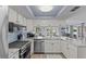 Bright kitchen features white cabinets, stainless steel appliances, and blue backsplash at 7626 Hatteras Dr, Hudson, FL 34667