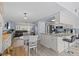 Open concept kitchen and dining area, featuring white cabinetry, a kitchen island, and a view into the living room at 7626 Hatteras Dr, Hudson, FL 34667