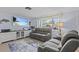 Inviting living room with comfortable gray couches, a large TV screen, and decor accents that evoke a coastal theme at 7626 Hatteras Dr, Hudson, FL 34667
