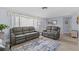 Cozy living room with comfortable gray sofas, a coastal-themed valance, and a neutral-toned rug with blue accents at 7626 Hatteras Dr, Hudson, FL 34667