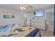 Main bedroom with light hardwood floors, ceiling fan and ensuite bathroom at 7626 Hatteras Dr, Hudson, FL 34667