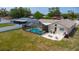 Backyard featuring a screened pool, patio, and grassy lawn at 8126 Wooden Dr, Spring Hill, FL 34606