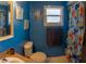 Blue bathroom featuring sink, toilet, mirror, nautical themed decorations and shower with curtain at 8126 Wooden Dr, Spring Hill, FL 34606