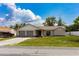 Attractive home featuring a two-car garage, green lawn, and beautiful landscaping at 8126 Wooden Dr, Spring Hill, FL 34606