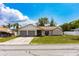 Inviting single-story house with a two-car garage, green lawn, and lovely blue sky at 8126 Wooden Dr, Spring Hill, FL 34606