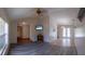 Open-concept living room boasts hardwood flooring, a ceiling fan, and an abundance of natural light at 8126 Wooden Dr, Spring Hill, FL 34606