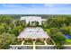 Aerial view of the community pool, clubhouse, tennis courts, and lake at 9124 Topneck St, New Port Richey, FL 34654