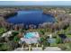 Aerial view of the community pool, clubhouse, tennis courts, and lake at 9124 Topneck St, New Port Richey, FL 34654