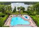Aerial view of the community pool with waterslide, clubhouse, and lake at 9124 Topneck St, New Port Richey, FL 34654