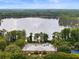 Aerial view of the community pool, clubhouse, tennis courts, and lake at 9124 Topneck St, New Port Richey, FL 34654