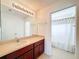 Bathroom with a large mirror, tan countertops, and an open view to a shower/tub combo at 9124 Topneck St, New Port Richey, FL 34654