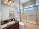 Bathroom featuring granite counter, framed mirror, and glass-enclosed tub/shower at 9124 Topneck St, New Port Richey, FL 34654