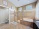 Large bathroom with soaking tub, walk-in shower, neutral colored walls, tiled floor, and plenty of natural light at 9124 Topneck St, New Port Richey, FL 34654