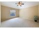 An airy bedroom with neutral carpet, one window, a ceiling fan, and large walls at 9124 Topneck St, New Port Richey, FL 34654